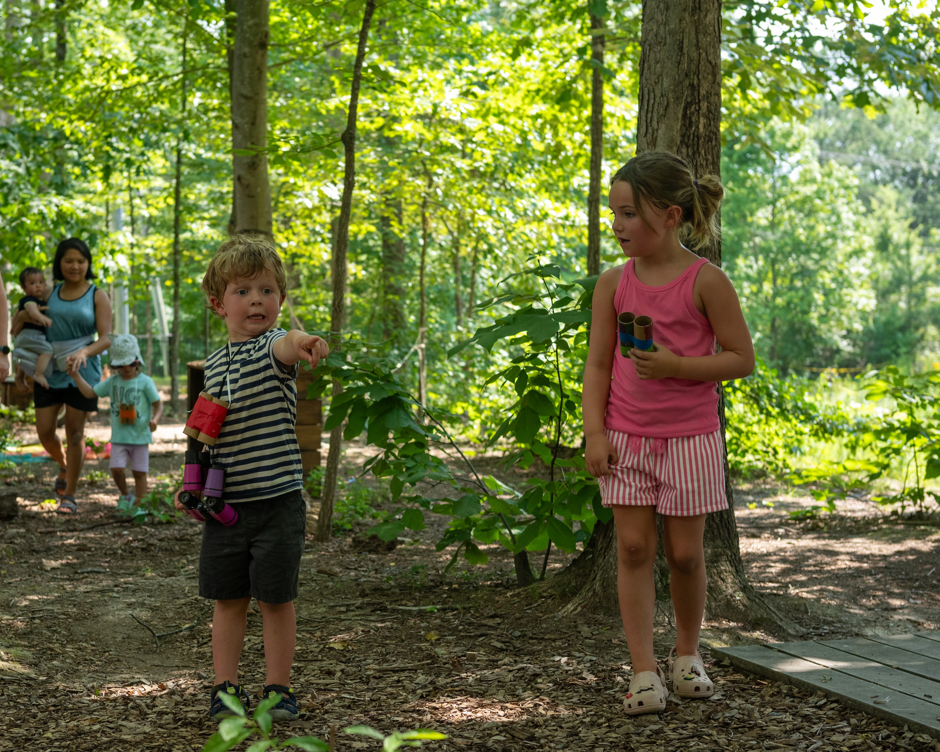 boy excitedly pointing in forest